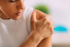 woman with sore shoulder Alliston physio clinic