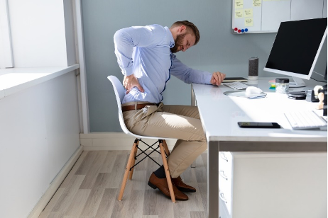 A well-organized ergonomic workstation setup to prevent neck and back pain, featuring proper chair height and monitor placement.