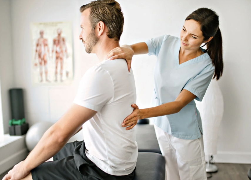 Physiotherapist performing shoulder and back assessment during physiotherapy session Physiotherapist performing shoulder and back assessment during physiotherapy session
